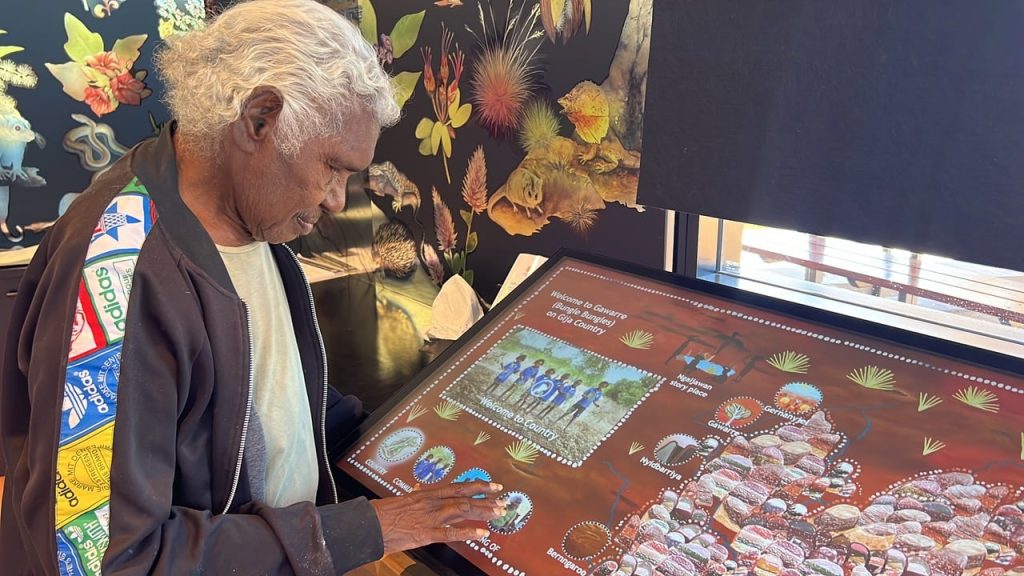 Senior Custodian Shirley Drill with the Jirraginy joo Goorrarndal - Frog and Brolga Interactive Display Panel at Purnululu National Park